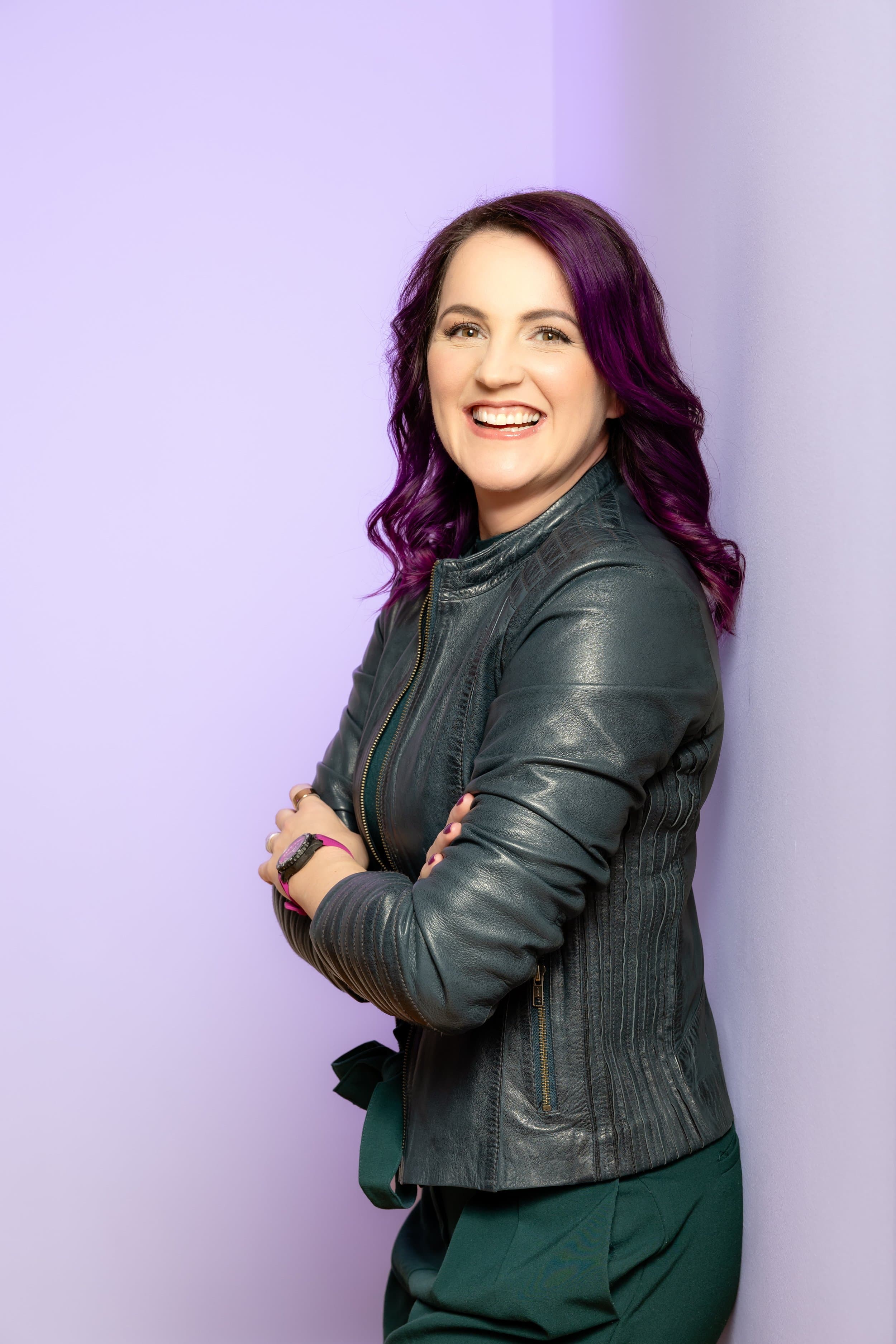 Jessica Deike, die Projektpilotin, lachend vor einer lila Wand